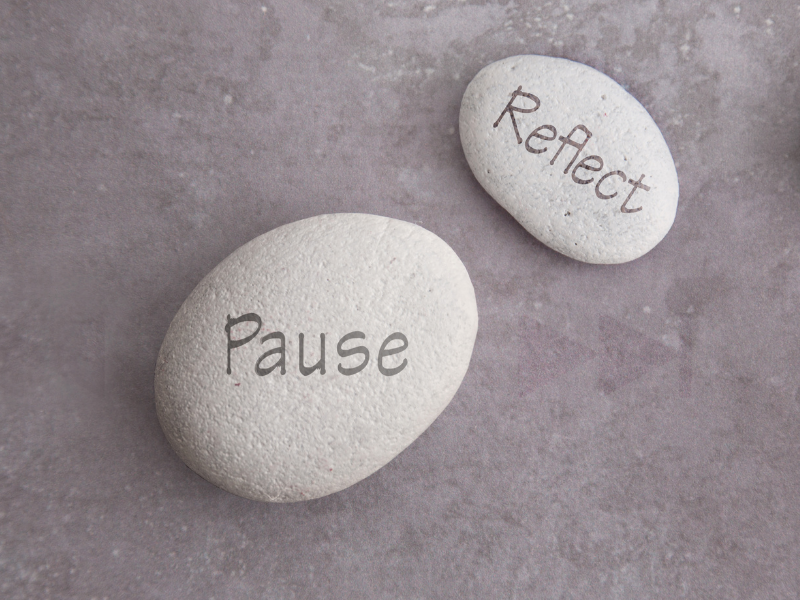 Two pebbles with inscriptions Pause and Reflect